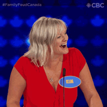 a woman in a red top with a name tag that says kim on it
