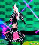 a woman in a polka dot dress is dancing in front of a green wall with a tumblr logo on the bottom right