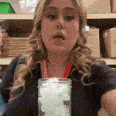 a woman is holding a jar of ice cubes in front of her