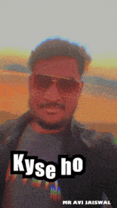 a man wearing sunglasses and a black jacket with the words " kyse ho " on the bottom