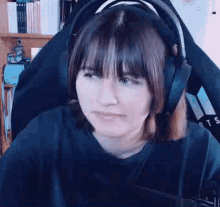 a young woman wearing headphones is sitting in a chair .