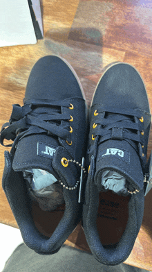 a pair of black cat shoes are on a wooden table