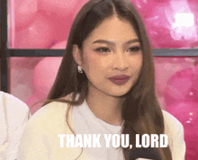 a woman says thank you lord in front of balloons