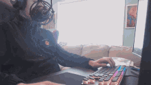 a man wearing headphones and a sweatshirt that says warriors on it is typing on a keyboard