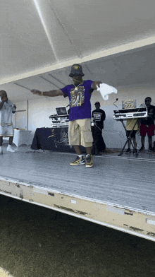 a man in a purple shirt with the number 21 on it stands on a stage