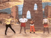 a group of people are dancing on a stage in front of a painting .