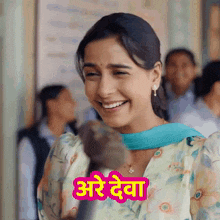a woman is smiling in front of a sign that says ' are deva '