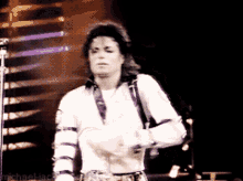 a man in a white shirt is dancing on a stage