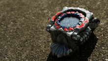 a silver and red toy with a compass on it