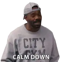 a man wearing a city gym sweatshirt and a hat says calm down