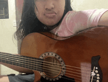 a girl is holding an acoustic guitar and making a face with her mouth open