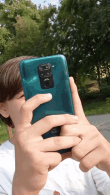 a person holding a green redmi phone in their hand