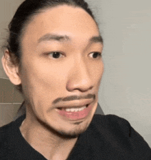a man with a beard is making a funny face .