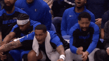 a group of basketball players are sitting in the stands and one of them is wearing a jersey that says magic