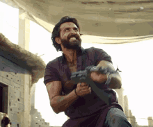 a man with a beard is holding a gun in his hands