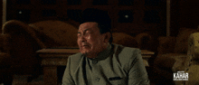a man is crying in front of a sign that says kahar on it