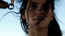 a close up of a woman 's face with a hook in the background