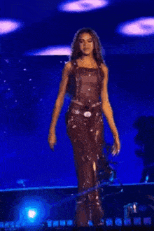 a woman is standing on a stage holding a microphone and dancing .