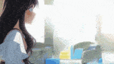 a girl with long hair is standing in front of a window in a classroom .