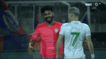 two soccer players are hugging each other and one has the number 7 on his shirt
