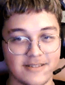 a close up of a man wearing glasses and headphones .