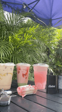 two cups of drinks sit on a table next to a riverside vape
