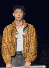 a young man wearing a leopard print jacket and a hello kitty necklace