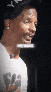 a man wearing a hat and a shirt that says ' snoop dogg ' on it talks into a microphone
