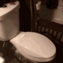 a white toilet is sitting in a bathroom next to a sink and a bathtub .