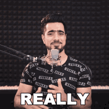 a man in front of a microphone has the word really on his shirt
