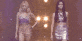 a group of women are dancing on a stage with a sign that says mo