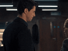 a man in a black shirt is hugging a woman in a dark room