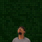 a man stands in front of a green background with the number 14 on it