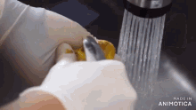 a person is washing something under a faucet that says made in animatica on the bottom