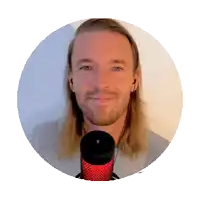 a man with long blonde hair and a beard is standing in front of a microphone