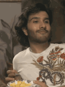 a man wearing a shirt that says spirit beast is eating food