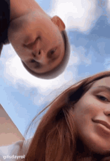 a man and a woman are looking up at the sky and smiling