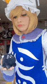 a woman in a blue and white dress holds a stuffed animal