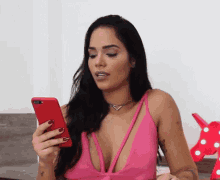 a woman in a pink top looks at her phone