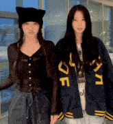 two girls standing next to each other one wearing a jacket that says def