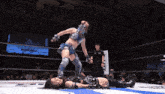 a woman in a mask is wrestling another woman in a ring with a sign behind them that says " a-live "