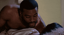 a shirtless man kissing a woman on the neck