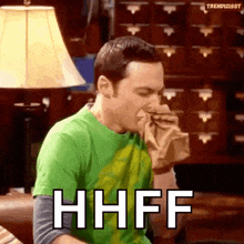 a man in a green shirt is blowing his nose and the word hhff is on the screen .