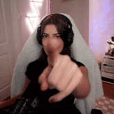 a woman wearing headphones is giving a thumbs up sign