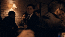 a man in a suit and tie stands in a crowd