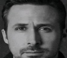 a close up of a man 's face with a beard and a serious look on his face .