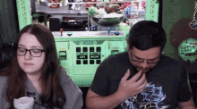 a man and a woman are playing a video game in front of a machine that says left and right .