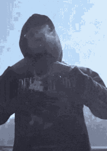 a man wearing a death hoodie smoking a cigarette