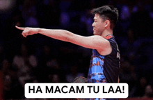 a man holding a badminton racket pointing at something with the words ha macam tu laa