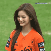 a woman wearing an orange shirt that says nucore